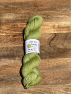 Green skein of yarn with a label on a wooden surface