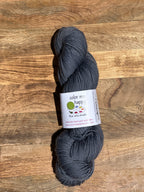 Blue skein of yarn with a label on a wooden surface