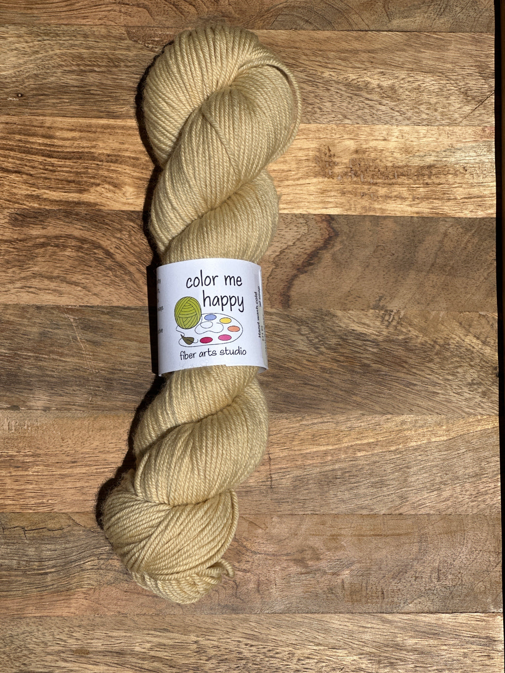 Beige skein of yarn with a label on a wooden surface