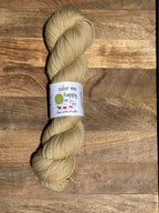 Beige skein of yarn with a label on a wooden surface