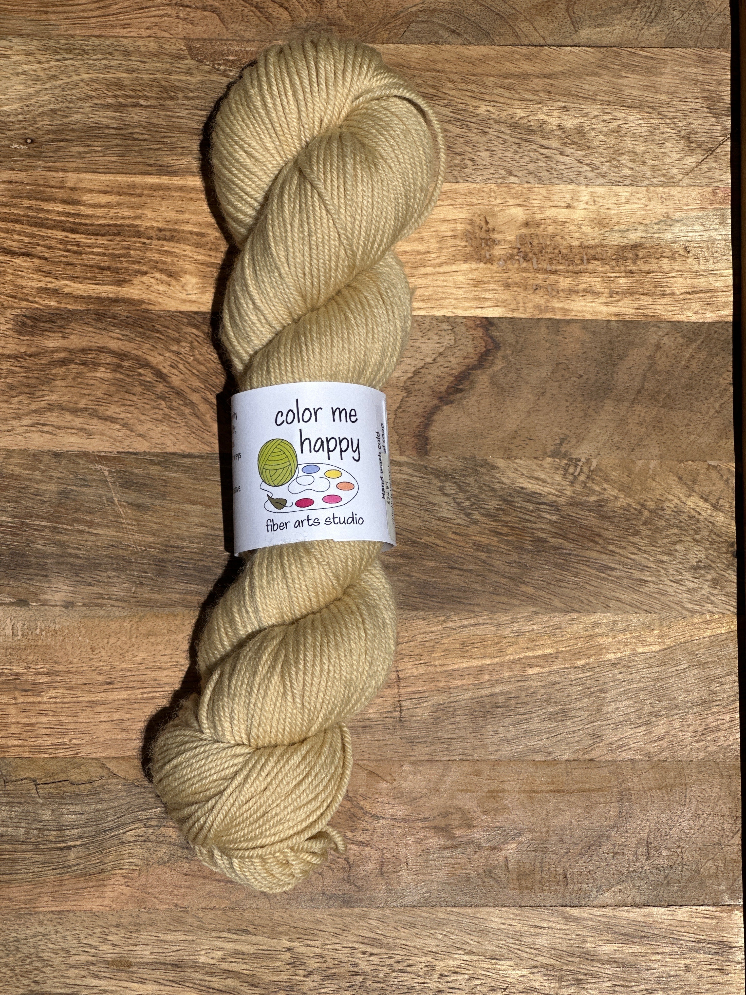 Beige skein of yarn with a label on a wooden surface