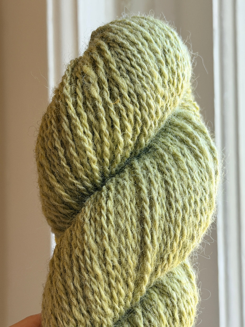 Close up of a green skein of yarn.