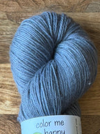 Blue skein of yarn with a label on a wooden surface