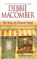 Book cover for 'The Shop on Blossom Street' by Debbie Macomber, featuring a storefront illustration with a green door, striped awning, and warm-toned window display.