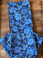 Folded blue floral fabric on a wooden surface