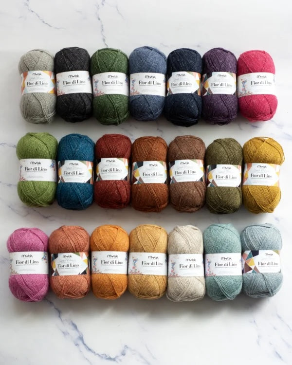 Assorted skeins of Myak Fior di Lino yarn in various colors on a white background