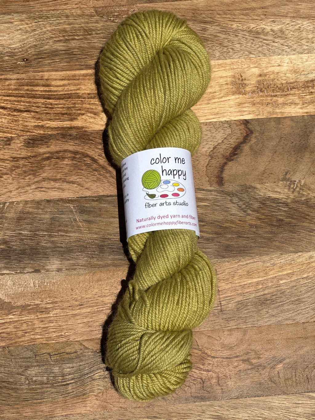 moss green skein of yarn on a wooden tray