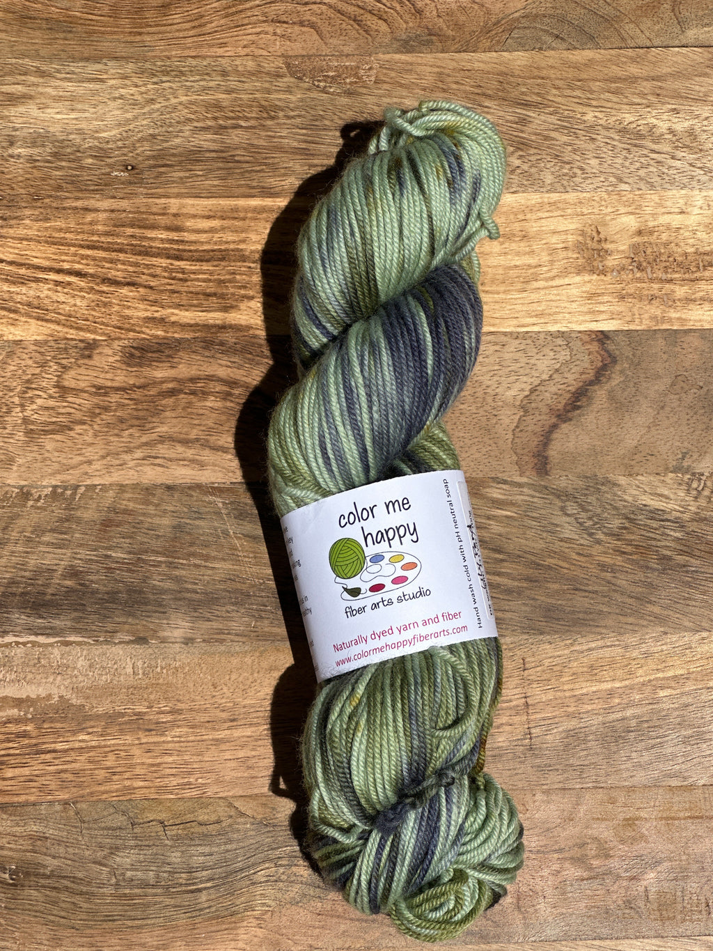 Green skein of yarn with a label on a wooden surface