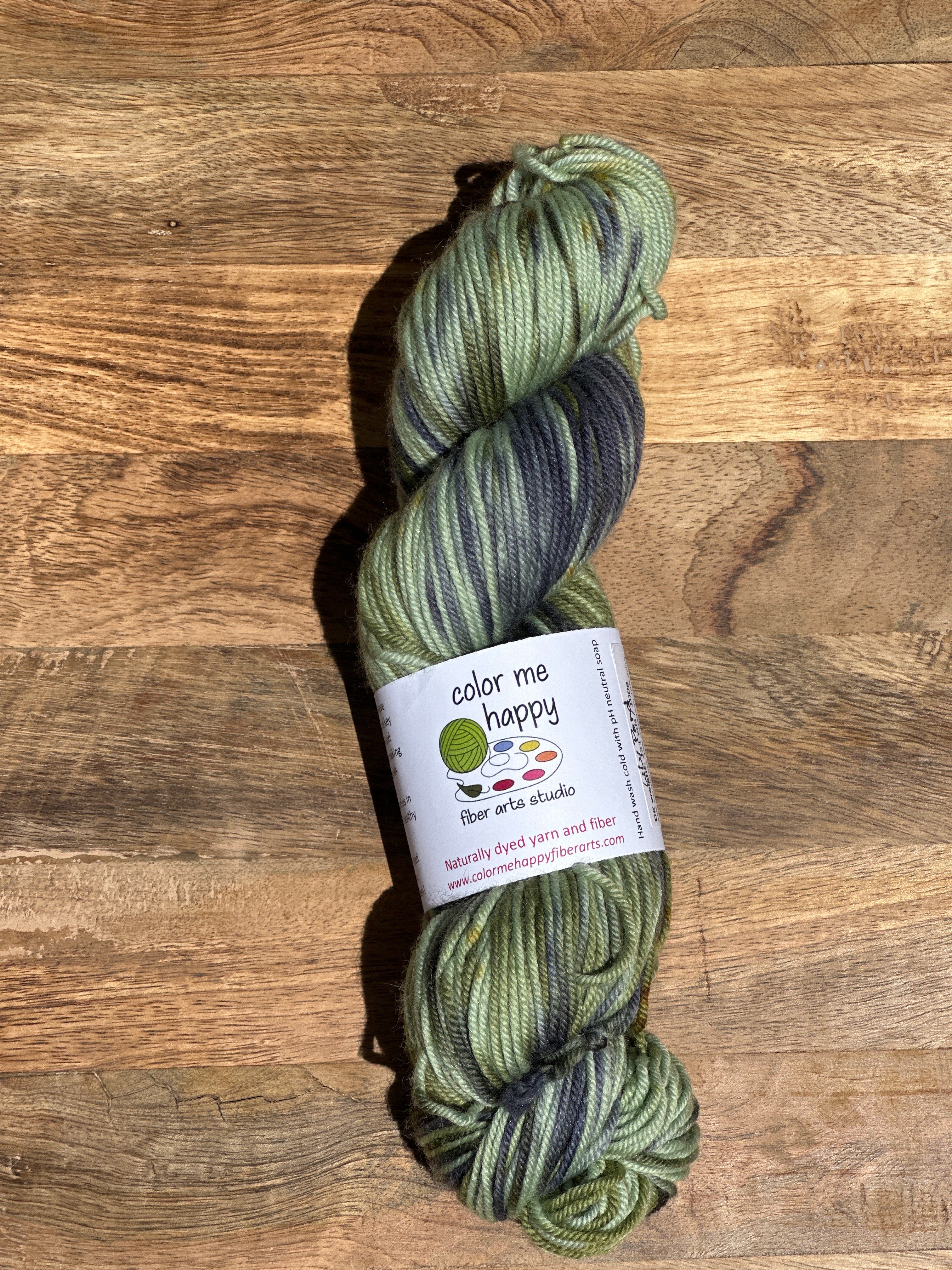 Green skein of yarn with a label on a wooden surface
