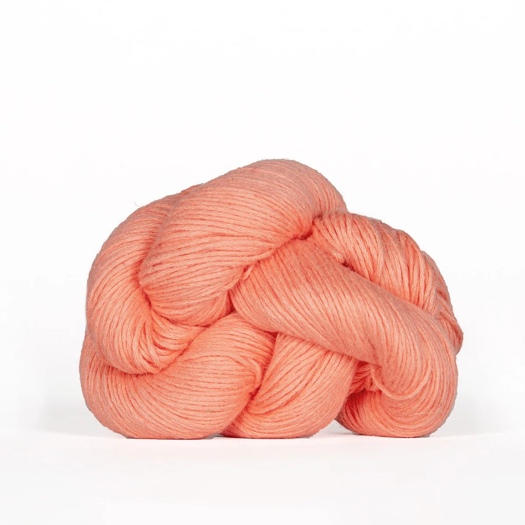 Peach-colored skein of yarn on a white background