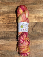 Multicolored skein of yarn with a label on a wooden surface